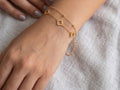 Gold-tone clover bead chain bracelet with three open clover motifs shown on a wrist