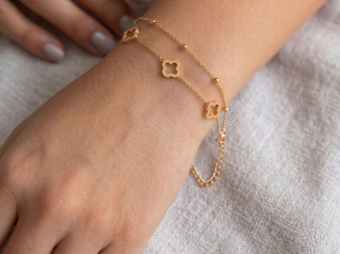 Gold-tone clover bead chain bracelet with three open clover motifs shown on a wrist
