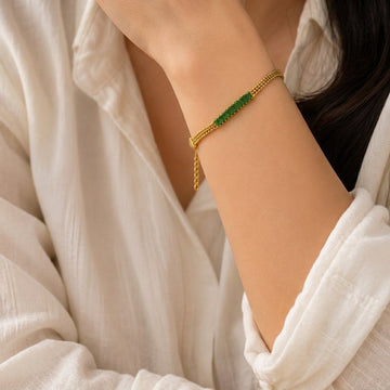 Gold-tone green stone mesh bracelet shown on a wrist